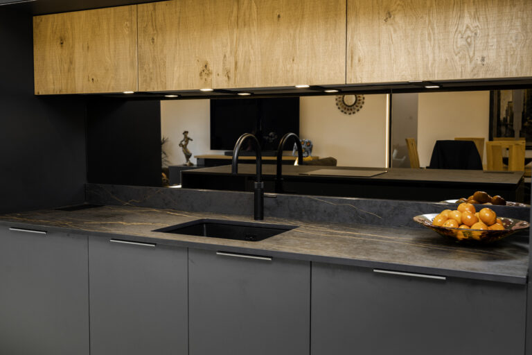 Laurent Porcelain worktop installed along a sink run beneath warm wood cabinetry, with a black tap and undermount sink.