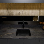 Laurent Porcelain worktop with gold veining, featuring an undermount sink and black tap beneath warm wood cabinetry.