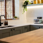 White Macaubus Quartz worktops in a modern kitchen with a sink run and wooden island, showing subtle veining