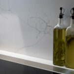 White Macaubus Quartz splashback and worktop detail showing subtle veining behind oil bottles