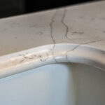 Gold Calacatta worktop with curved sink edge and warm veining