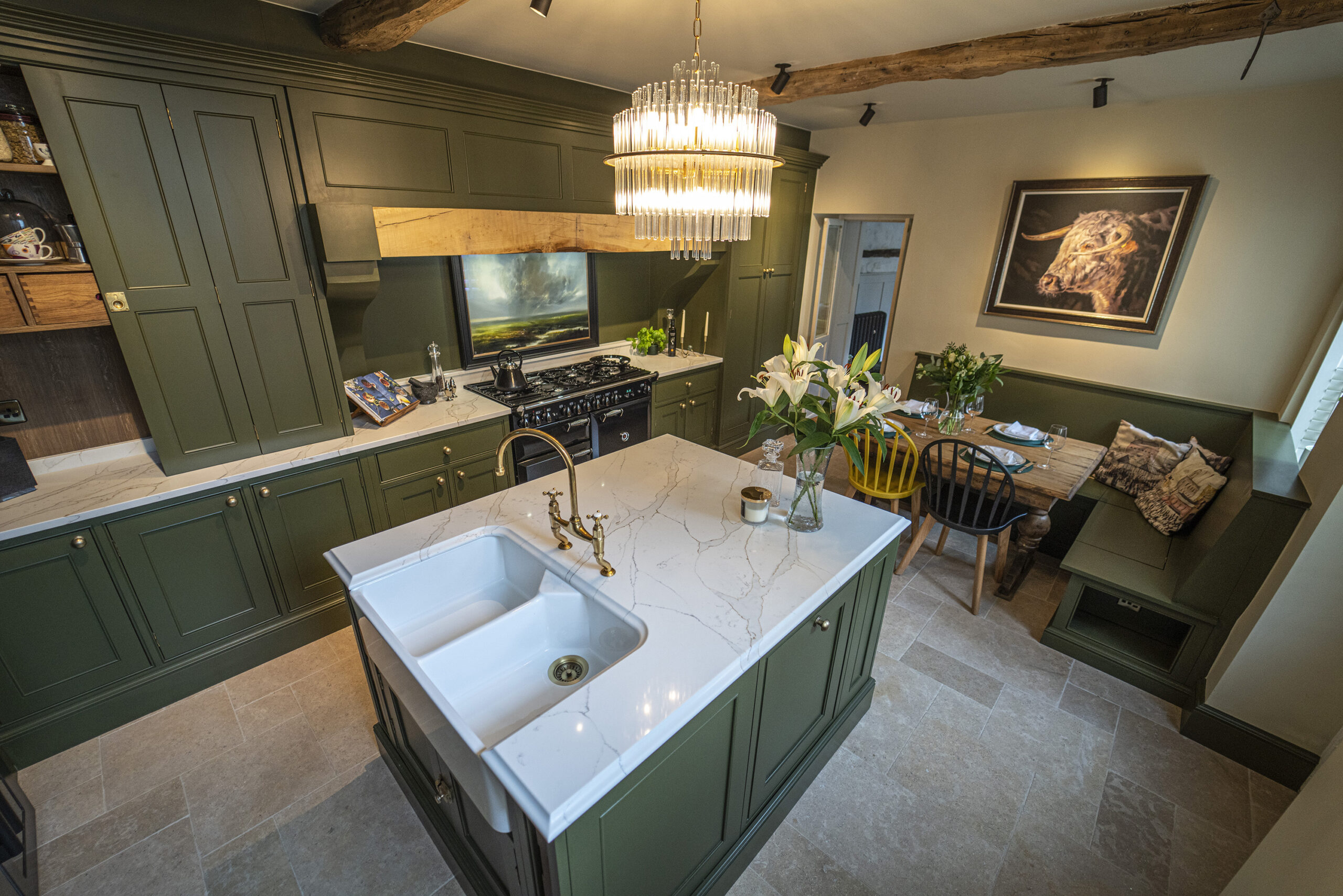 Traditional kitchen with Gold Calacatta island, green cabinetry and chandelier lighting