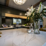 Gold Calacatta kitchen island with floral arrangement and warm natural veining