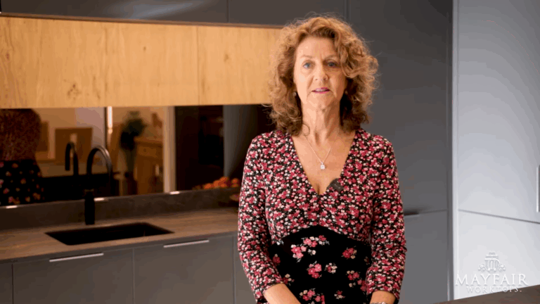 Customer testimonial portrait for a Laurent Porcelain worktop project, photographed in a modern showroom kitchen setting.