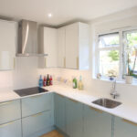 Dover White Quartz worktops in a bright kitchen corner with a sink run and smooth white finish