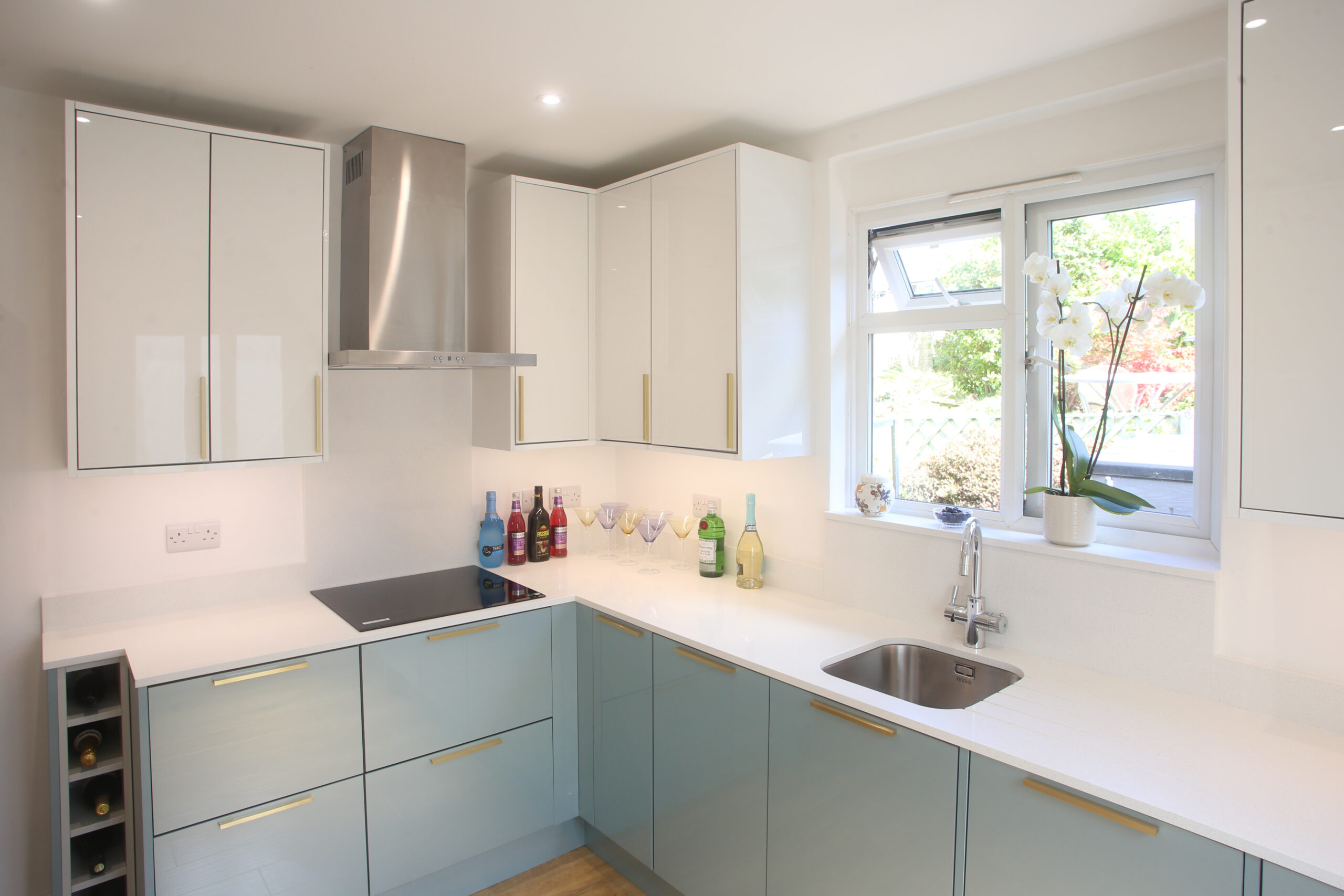 Dover White Quartz worktops in a bright kitchen corner with a sink run and smooth white finish