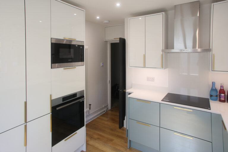 Dover White Quartz worktop run with an induction hob in a modern kitchen with light cabinetry