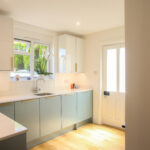 Bright kitchen with Dover White Quartz worktops along the main run, showing a smooth white surface finish