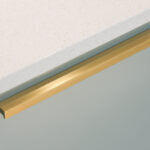 Dover White Quartz worktop edge close-up above pale green cabinetry showing a smooth white finish