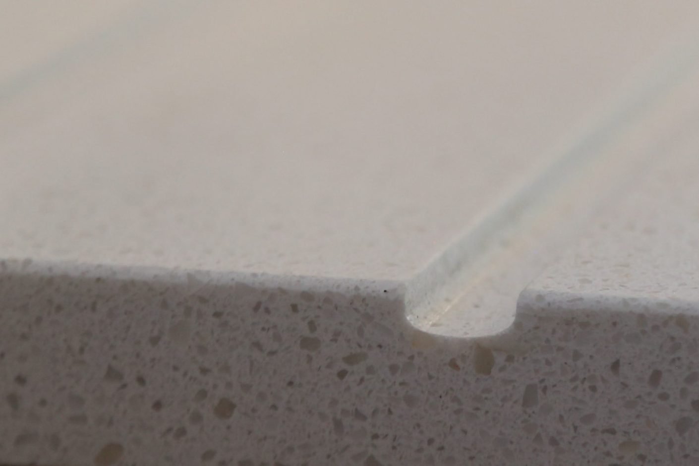 Close-up of Dover White Quartz worktop edge showing a smooth finish and fine speckled texture