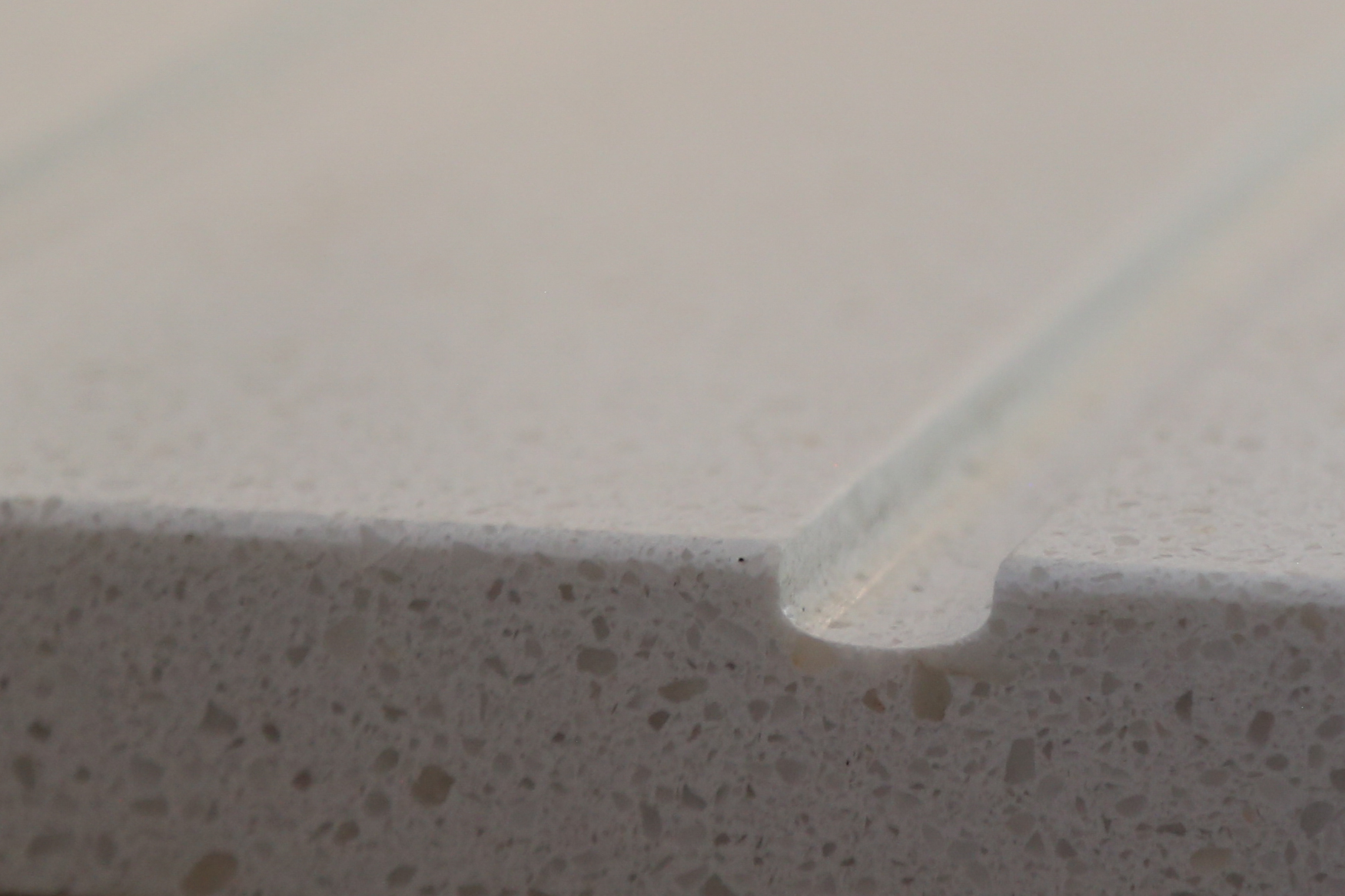 Close-up of Dover White Quartz worktop edge showing a smooth finish and fine speckled texture