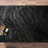 Overhead view of a Black Storm Granite island worktop showing bold natural veining, photographed from above with a small styled tray in the corner.
