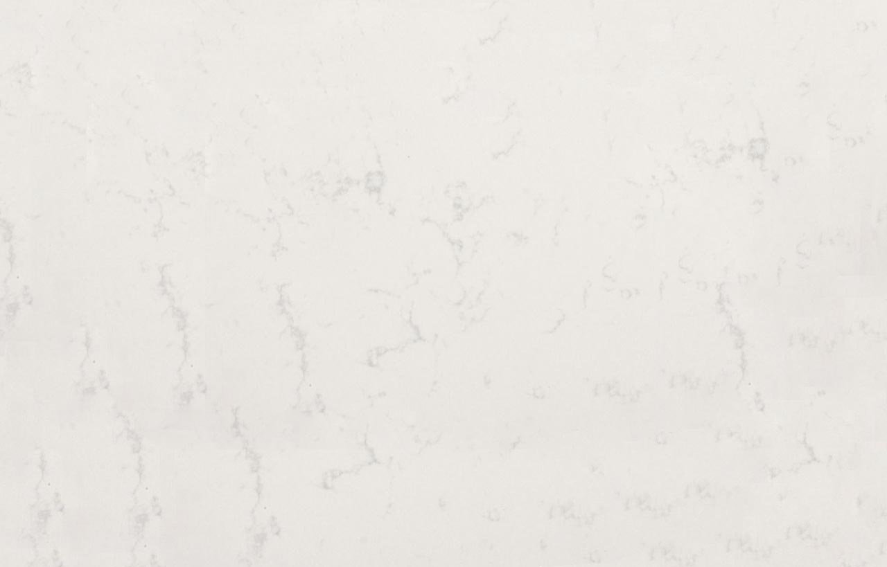 Close up of Carrara Quartz surface showing soft white background and light grey veining