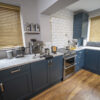 Arabescato Quartz worktops throughout a kitchen with dark blue cabinetry, showing grey veining across the bright surface