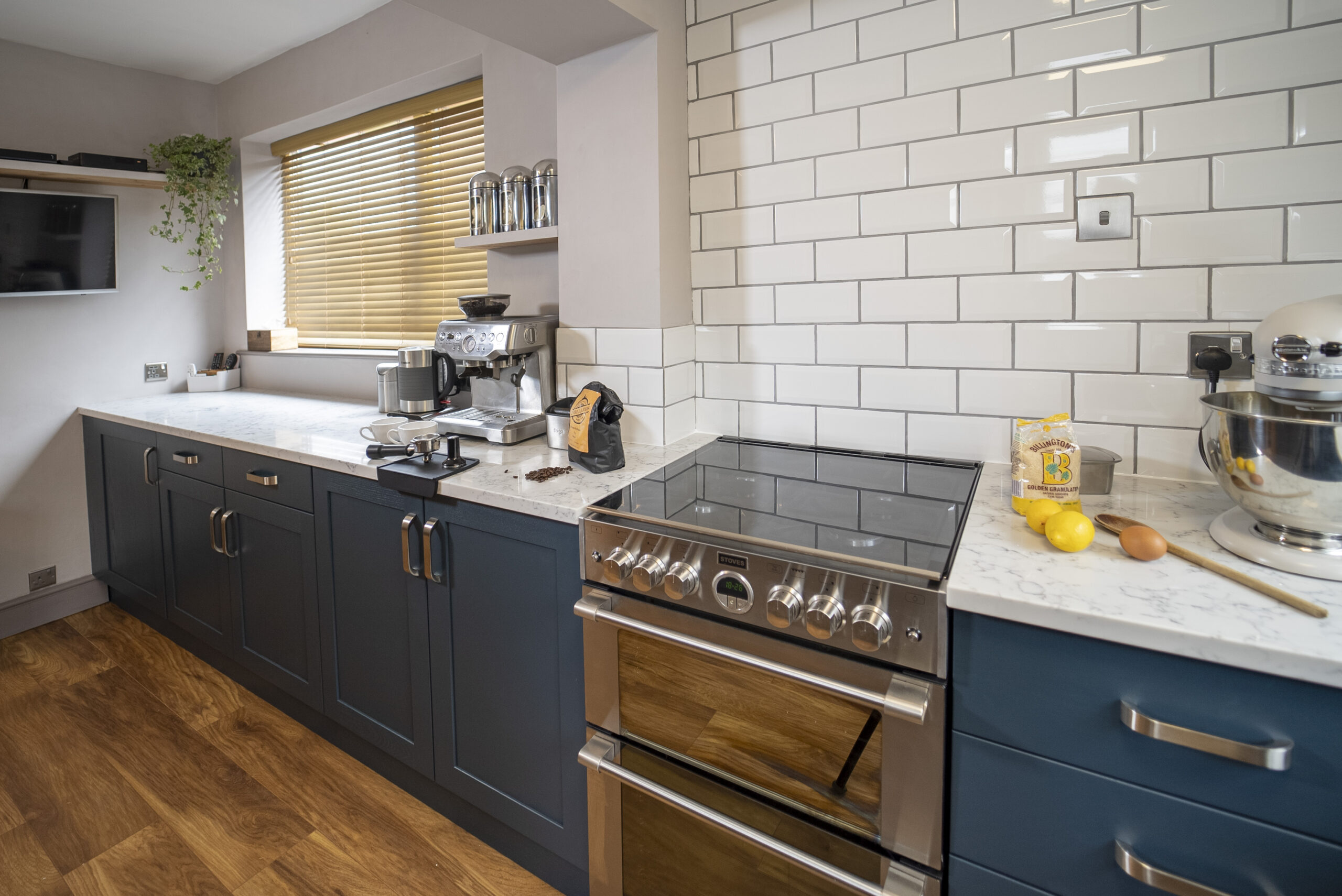 Arabescato Quartz worktop run beside a range cooker with grey veining and a white tiled splashback