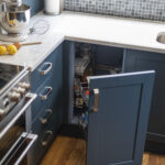 Arabescato Quartz worktop in a corner kitchen run with dark blue cabinetry and grey veining across the surface