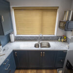 Overhead view of Arabescato Quartz worktops around a double sink in a kitchen with dark cabinets