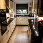 Wide view of a traditional kitchen with Star Galaxy Granite worktops, showing the long perimeter run, sink area and polished reflective finish.