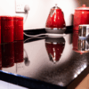 Close up of Star Galaxy Granite worktop with a polished reflective finish, showing sparkling flecks and red kitchen accessories reflected on the surface.