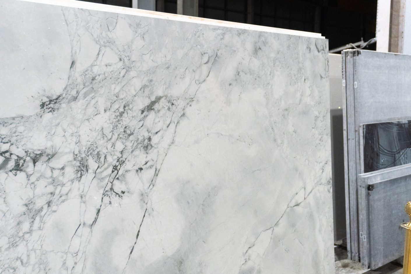 Calacatta Super White Porcelain slab edge view showing a bright white base with layered grey veining and soft shading