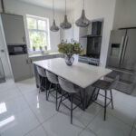 Modern kitchen with a Classic White Quartz island worktop and seating, showing a smooth white surface finish