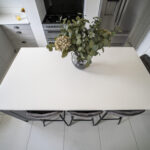 Overhead view of a Classic White Quartz kitchen island showing a smooth bright surface with seating below