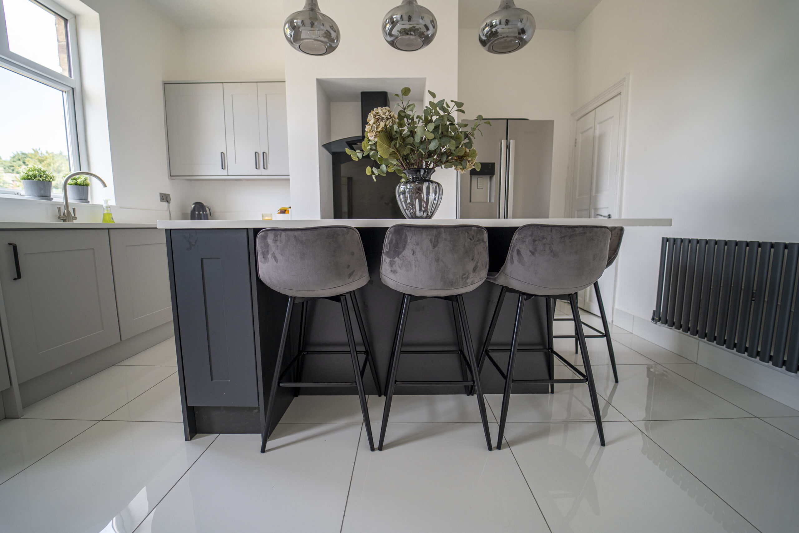 Classic White Quartz breakfast bar island with bar stools, showing a smooth white surface finish