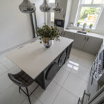 Angled view of a Classic White Quartz island worktop with seating, showing a smooth bright surface