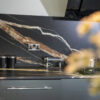Noir St Laurent Porcelain worktop and splashback installed with bold gold and copper veining, shown above grey kitchen units with a socket on the wall.
