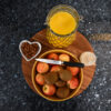 Overhead styling shot of a Blue Pearl Granite worktop with a breakfast tray, fruit bowl and orange juice, showing the dark speckled Granite surface.