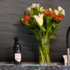 Blue Pearl Granite worktop detail with a vase of flowers and a wine bottle, showing the speckled Granite surface against a dark splashback.