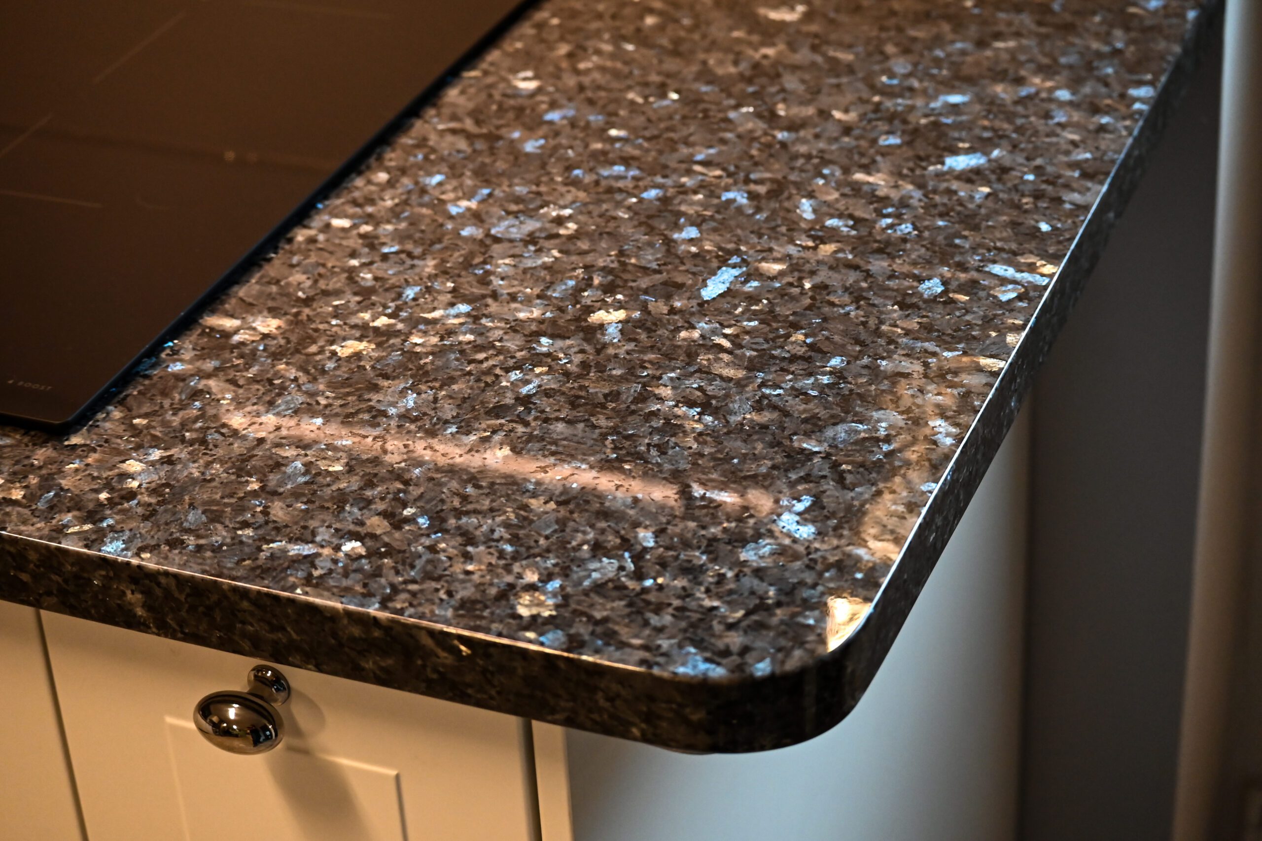 Close up of a Blue Pearl Granite worktop corner showing the rounded edge profile and shimmering blue crystal flecks in the polished surface.