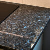 Close up of a Blue Pearl Granite worktop corner showing the rounded edge profile and shimmering blue crystal flecks in the polished surface.
