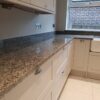 Worktop run in Azul Platino Granite on light cabinetry, showing the polished speckled Granite surface along the wall with a clean straight edge profile.