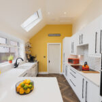 Wide kitchen view showing Ice White Quartz worktops with a breakfast bar surface and smooth white finish