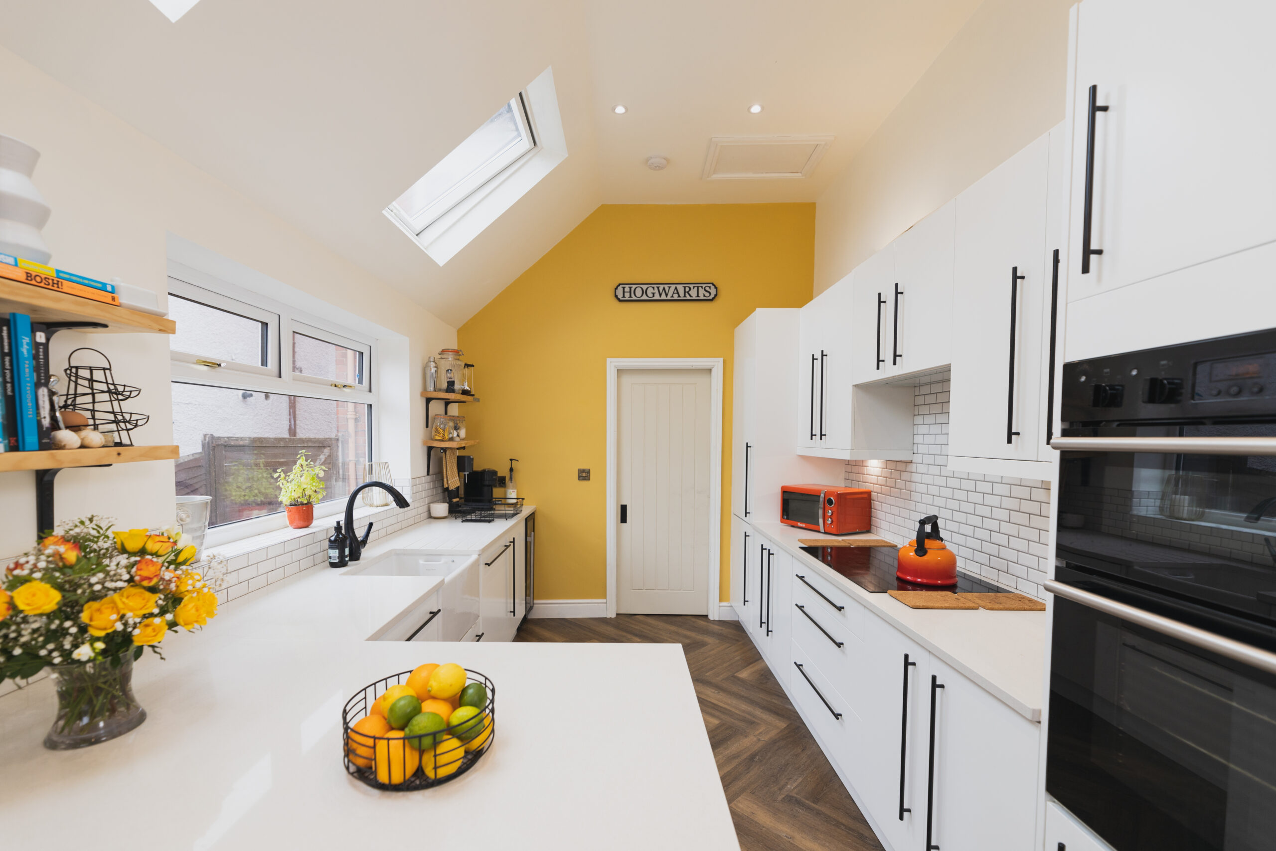 Wide kitchen view showing Ice White Quartz worktops with a breakfast bar surface and smooth white finish