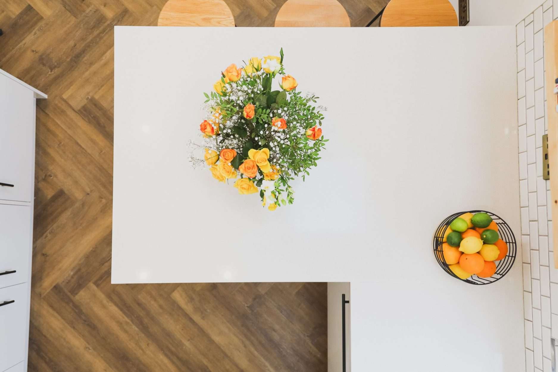 Overhead view of Ice White Quartz worktop surface with a floral arrangement on a smooth white finish