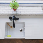 Overhead view of an Ice White Quartz sink run with drainer grooves, inset sink and black tap