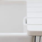 Close-up of Ice White Quartz worktop edge beside a sink, showing a smooth rounded corner and bright finish