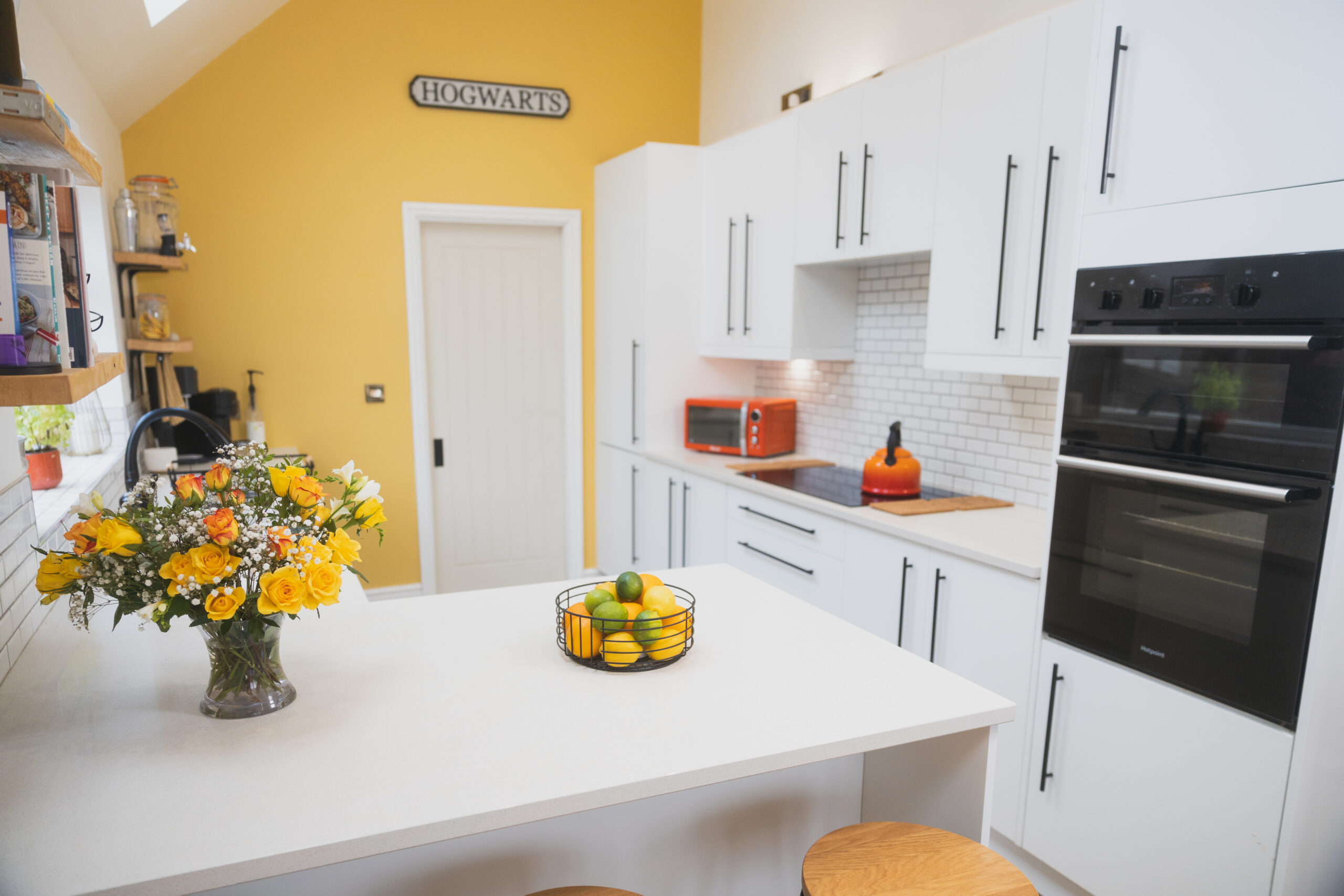 Ice White Quartz island worktop with a smooth white finish in a bright kitchen with white cabinets