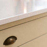 Ice White Quartz worktop edge close-up above cream kitchen drawers showing a clean, straight profile
