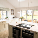 Open-plan kitchen with Ice White Quartz island worktop and pendant lighting above the bright white surface