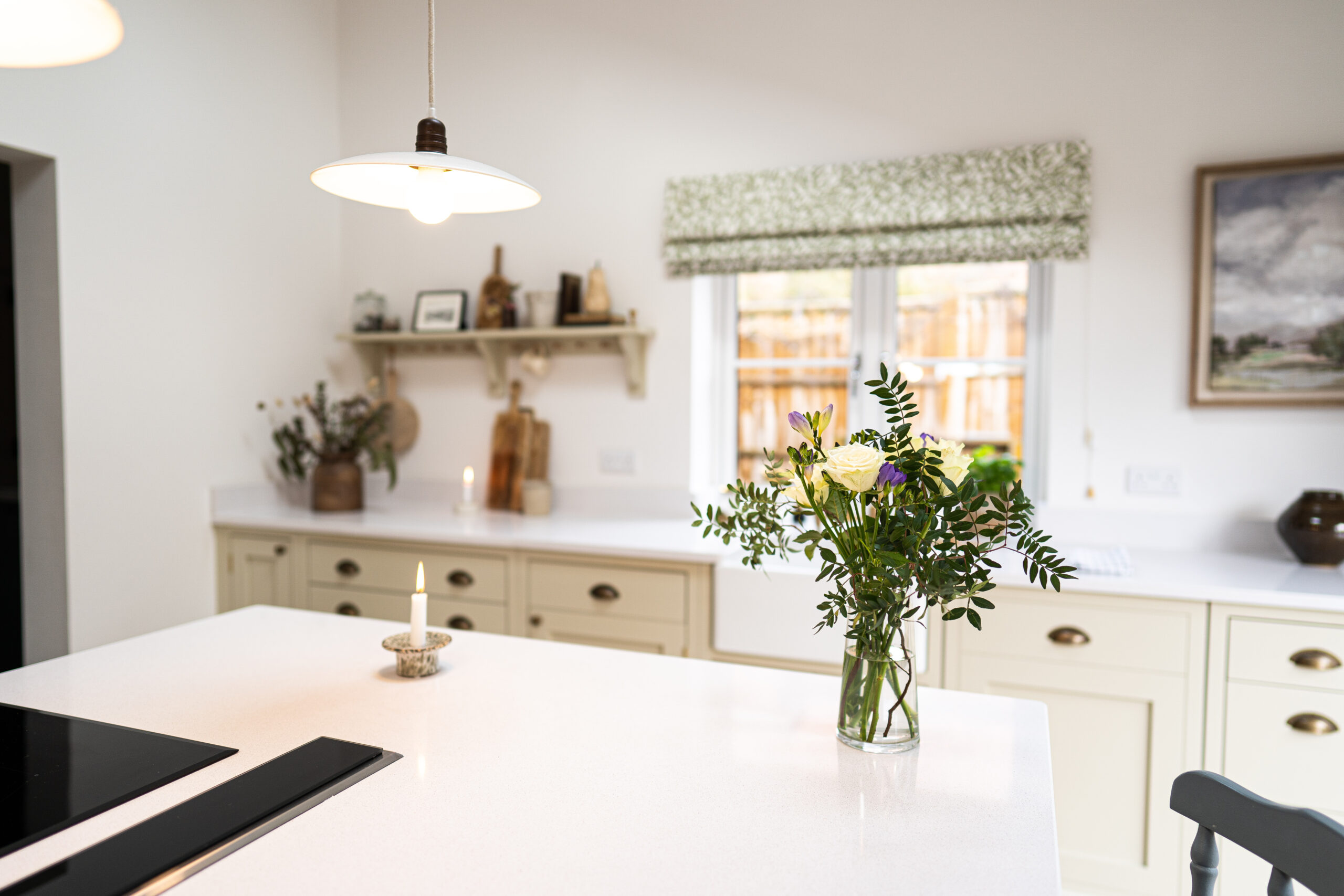 Ice White Quartz island worktop in a bright kitchen with a smooth white finish and fresh flowers on the surface