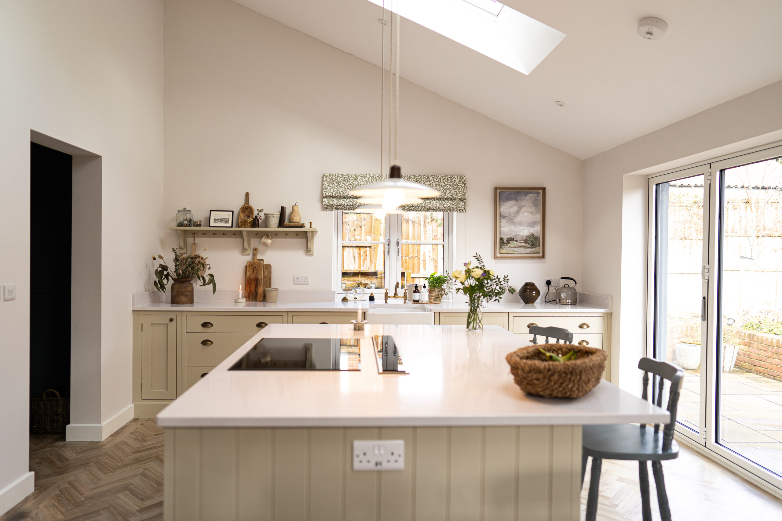 Long view of a kitchen island with Ice White Quartz worktop and integrated hob, showing a smooth bright surface