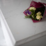 Statuario Bianco Porcelain worktop edge with subtle veining and flowers styled on the surface