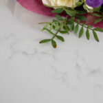 Statuario Bianco Porcelain worktop surface with flowers showing soft grey veining