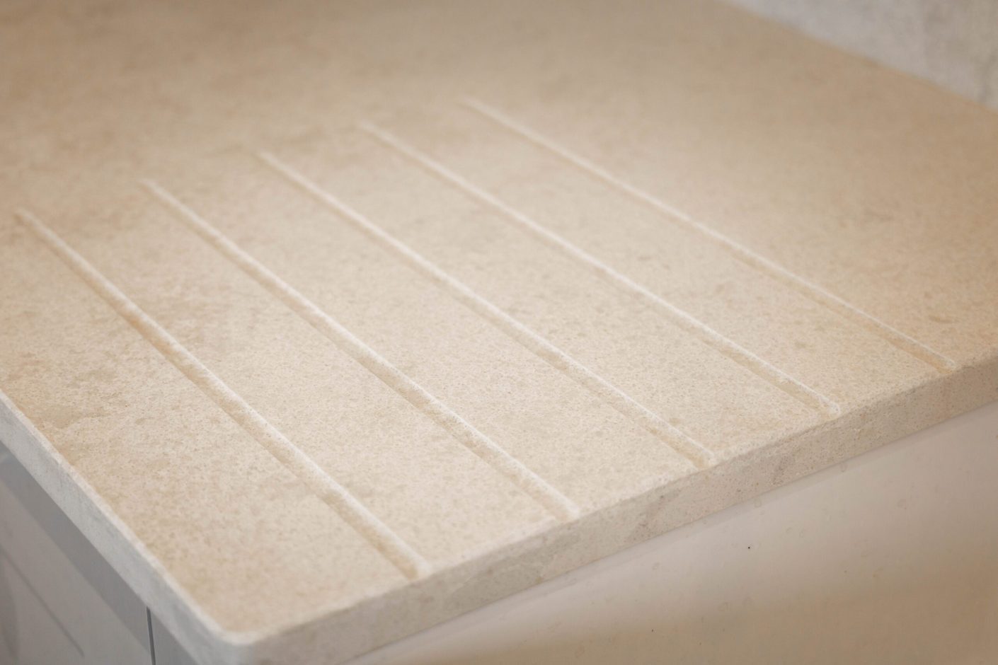 White Concrete Quartz worktop close-up showing integrated drainer grooves and smooth concrete-effect finish