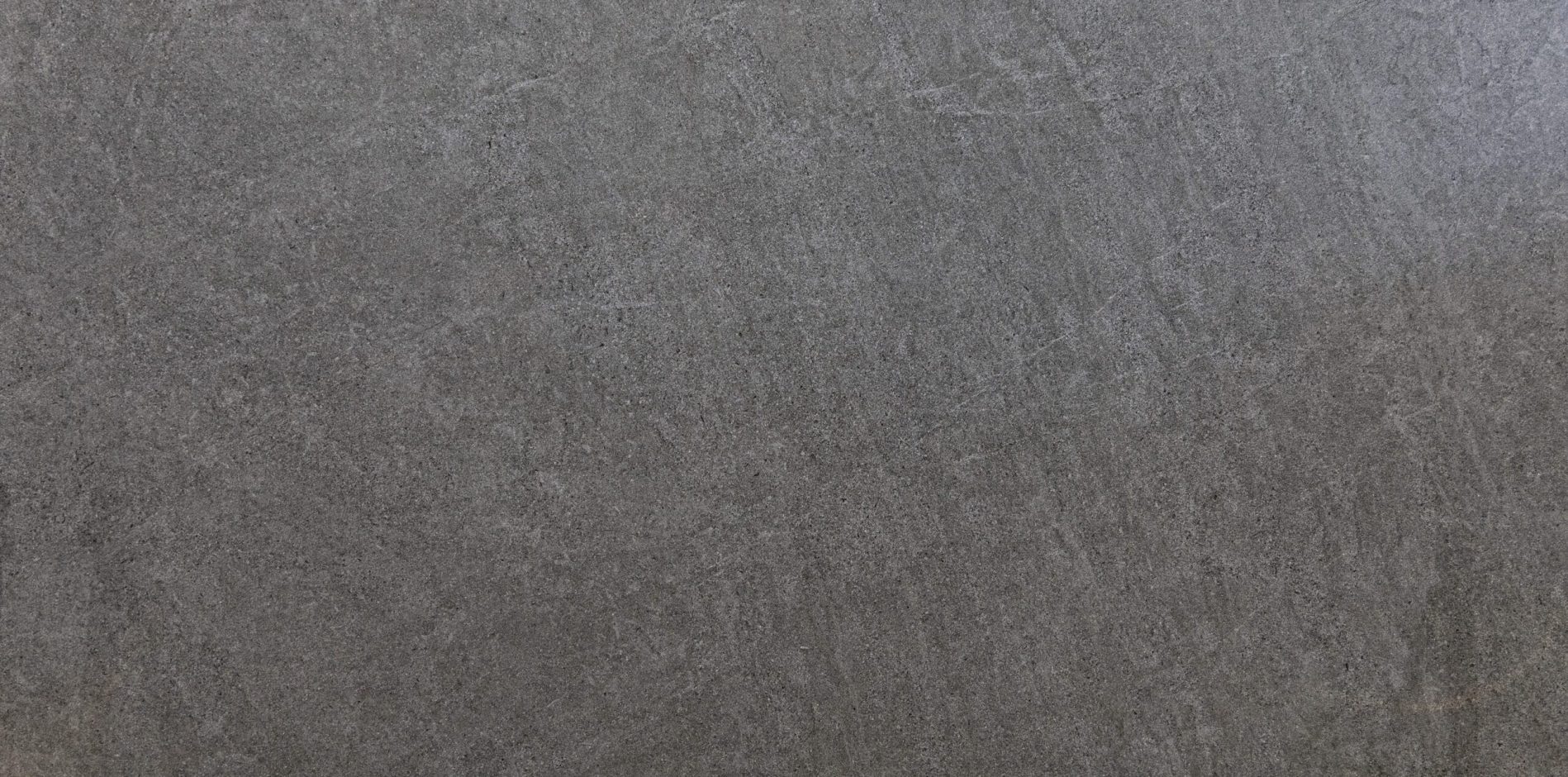 Pierre Bleue Porcelain close-up showing a mid to dark grey stone effect surface with subtle texture and gentle tonal variation