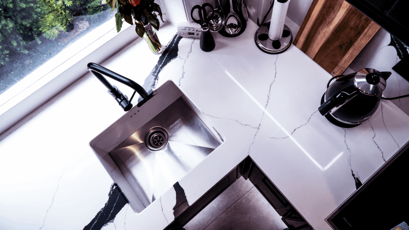 Black Calacatta Quartz worktop with inset stainless steel sink shown from above with bold veining nearby