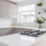 Bright kitchen view featuring Bluetta Carrara Quartz worktops with a hob set into the smooth white surface